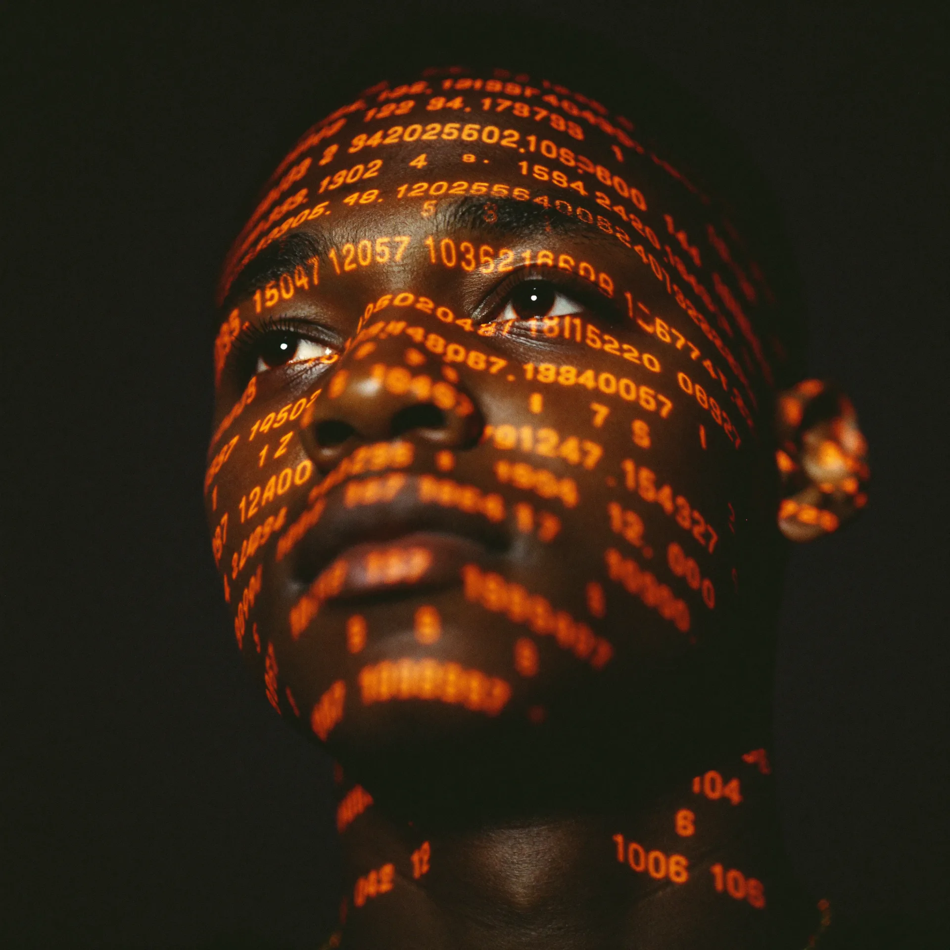 A founder lit by projected lines of code